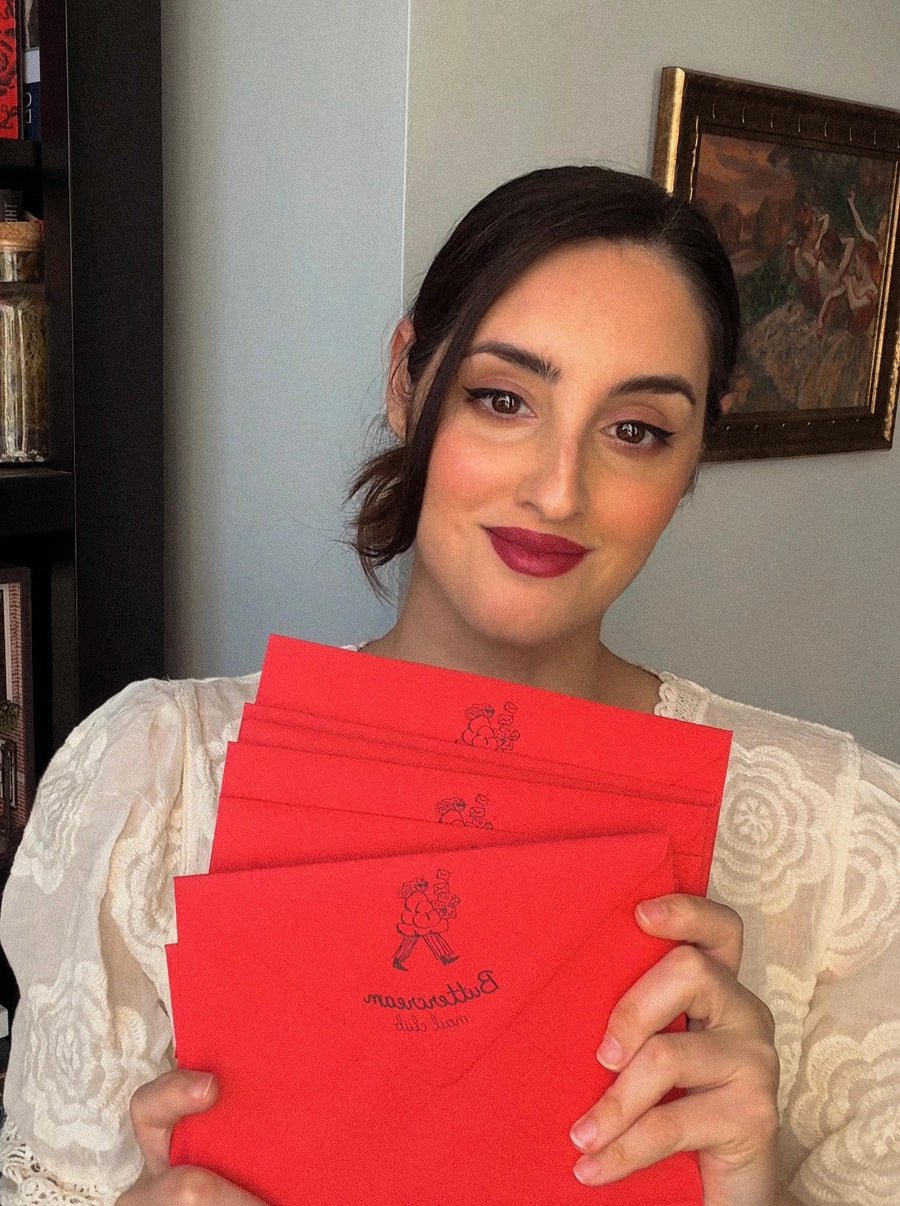 Tracy holding a Buttercream Mail Club envelope.